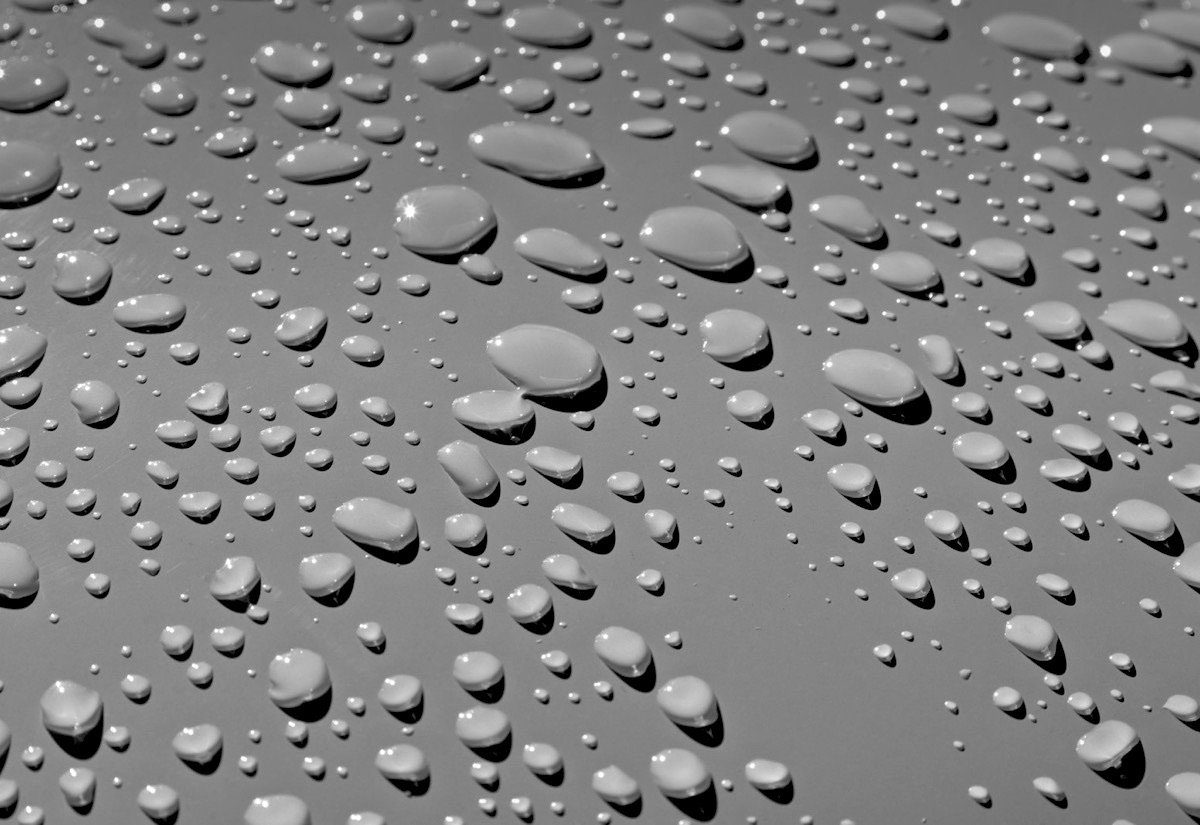 Water beading into round droplets on a hydrophobic car finish